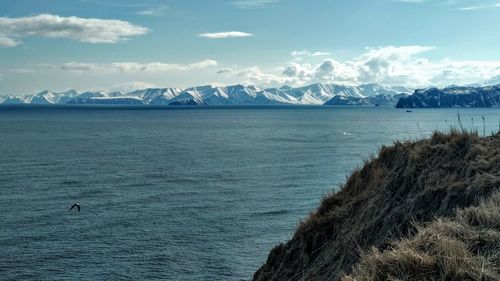 Scenic view of sea and mountains against sky