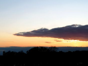 Scenic view of silhouette mountains against orange sky