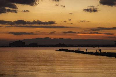 Sunset view of roses beach in costa brava in catalonia, showing some people silhouettes