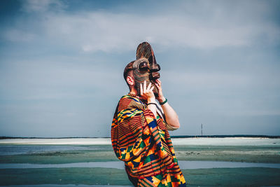 Midsection of  man at beach against sky