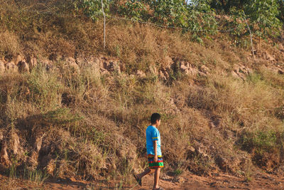 Rear view of boy walking on land