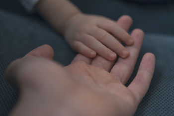 Cropped hands of parent and baby