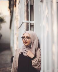 Portrait of young woman wearing sunglasses standing outdoors