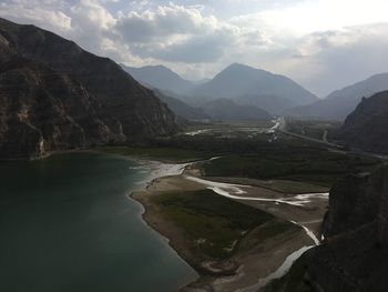 Scenic view of river and mountains against sky