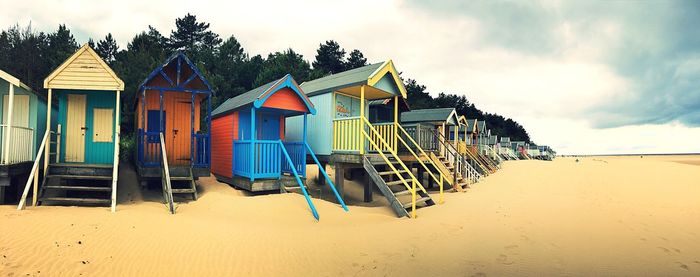 Multi colored umbrellas on beach against sky