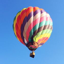 Low angle view of hot air balloon against clear blue sky