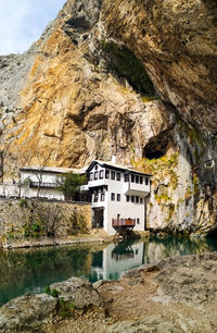 Rock formations by lake against buildings