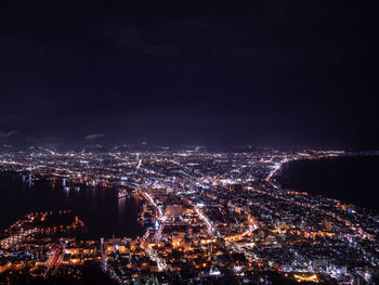 High angle view of illuminated cityscape against sky at night