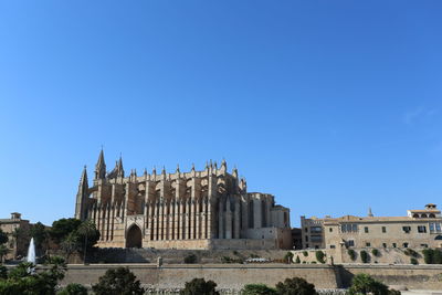 Low angle view of buildings against clear blue sky