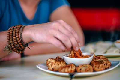 Close-up of man holding ice cream on table