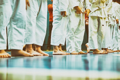 Low section of people standing by swimming pool