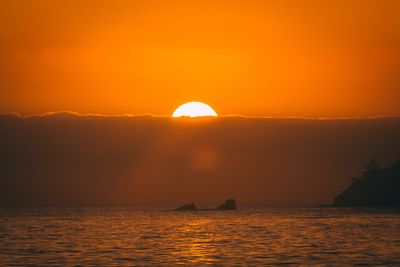 Scenic view of sea against orange sky