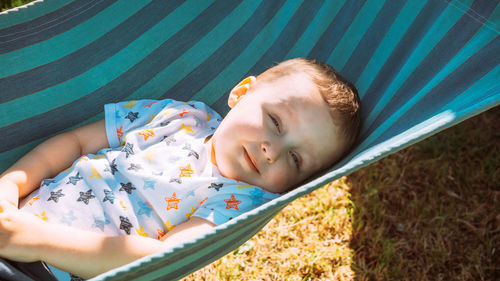 High angle portrait of cute boy lying on hammock