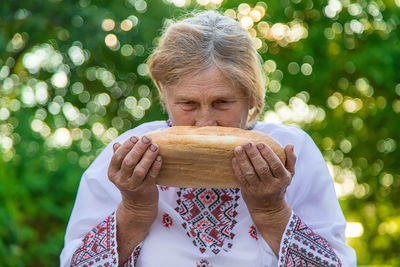Woman smelling bread outdoors