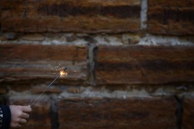 Close-up of hand holding sparkler at night