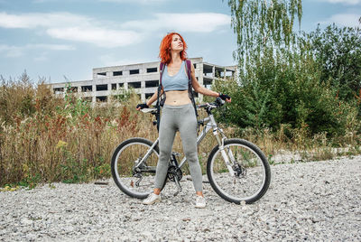 Rear view of woman riding bicycle on field