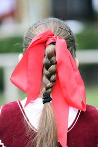 Red ribbon tied on braided hair