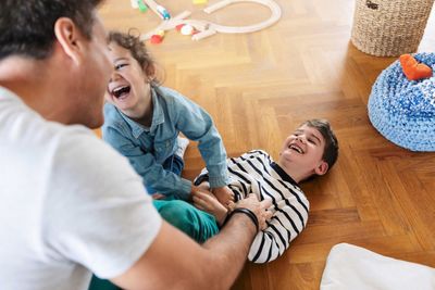 High angle view of father playing with children at home