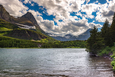 Scenic view of lake by mountains against sky