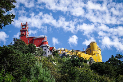 Low angle view of trees and buildings against sky