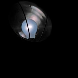 Low angle view of illuminated lamp against black background