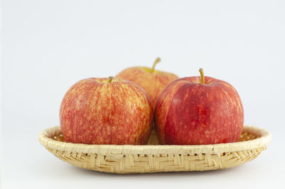 Close-up of fruits in basket against white background
