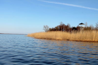 Scenic view of lake against clear blue sky