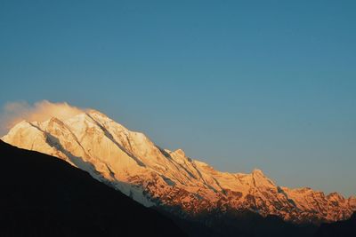 Scenic view of snowcapped mountains against clear blue sky