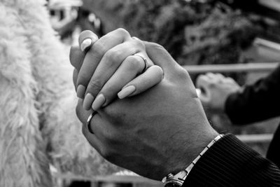 Cropped image of couple holding hand outdoors