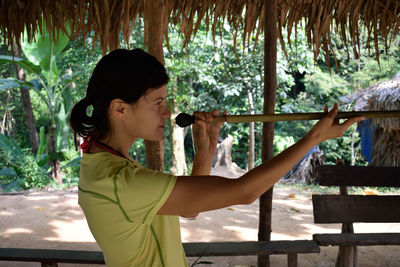 Side view of woman holding blowgun at taman negara national park