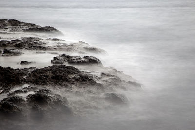 Scenic view of rocky coastline against sky