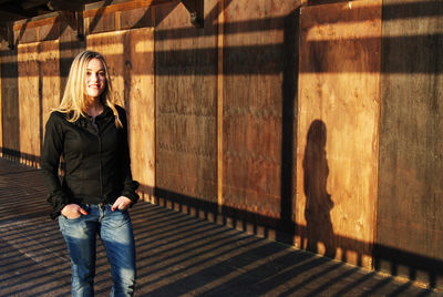 Portrait of woman standing against wall