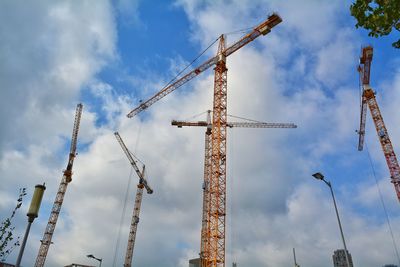 Low angle view of cranes against sky