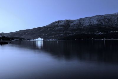 Scenic view of lake and mountains against clear sky