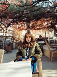 Portrait of young woman sitting on street