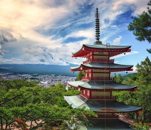 Temple in city against sky