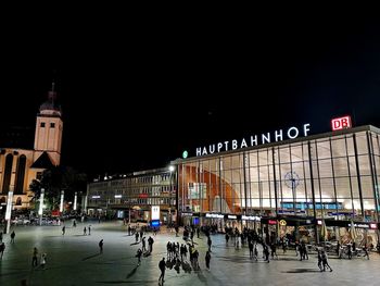 People walking on illuminated building at night