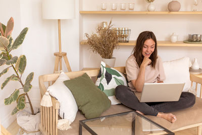 Young woman using mobile phone at home