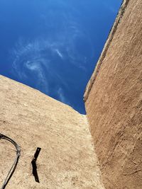 Low angle view of wall against blue sky