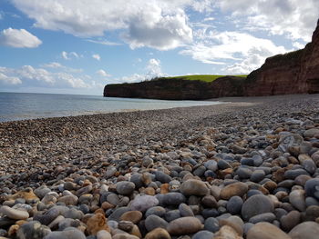 Surface level of stones on beach against sky