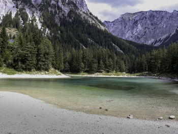 Scenic view of lake by mountains against sky