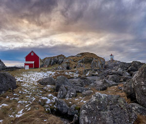 Cabins on haramsøya with wind farm turbines on top of its mountain, Ålesund, møre og romsdal, norway