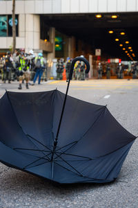 Close-up of wet umbrella on street in city