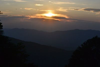 Scenic view of silhouette mountains against sky at sunset