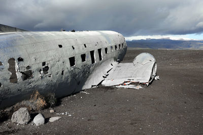 Abandoned airplane on land against sky