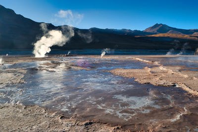 Smoke emitting from volcanic mountain against sky