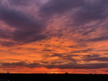 Scenic view of dramatic sky over silhouette landscape