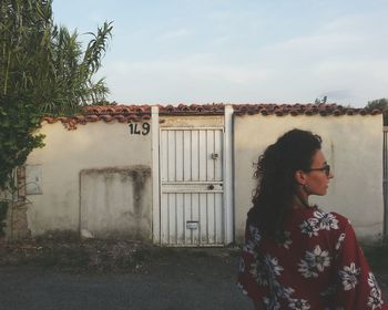 Woman standing by plants against sky