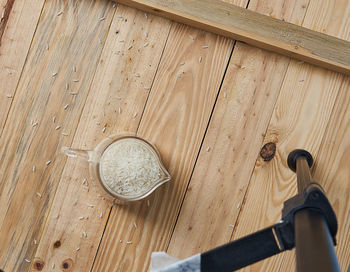 High angle view of rice on container on wooden table