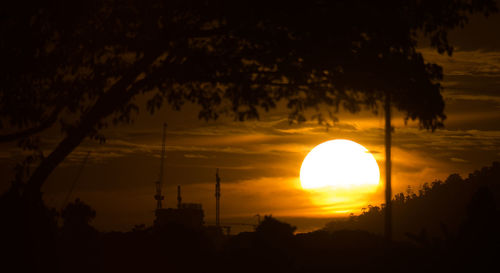 Silhouette trees against scenic sky